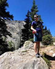 Jacob Thomas photo, outside with trees and mountains in the back